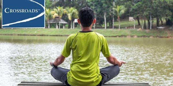 man using holistic meditation yoga on a dock to enhance addiction treatment healing