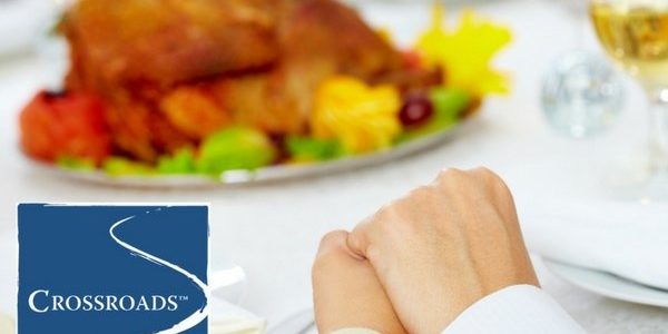 embracing hands in gratitude at Thanksgiving meal