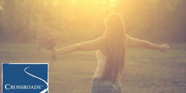 woman holding flowers and embracing the sun to start the year off fresh