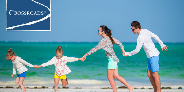 family pulling each other along on the beach to overcome bad days on vacation