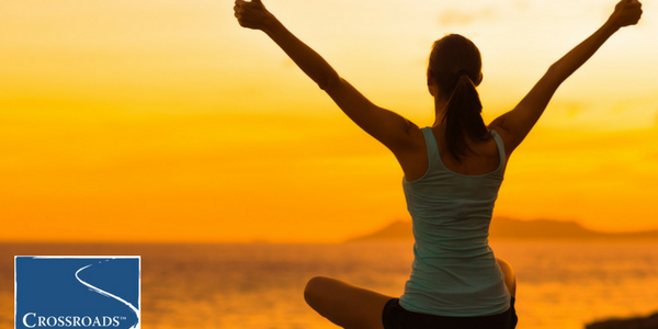 woman caring for herself with outdoor yoga at Crossroads