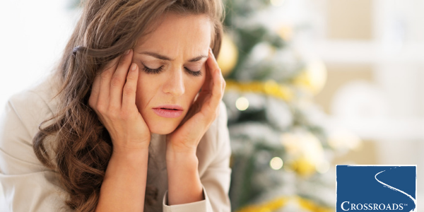 Common Holiday Stressors in Recovery.CRBlog1 woman massaging head dealing with common holiday stressors in recovery