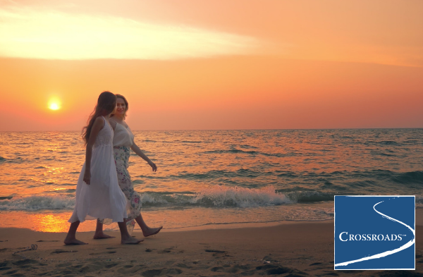 two women strolling down the beach at sunset discussing the right drug and alcohol treatment center