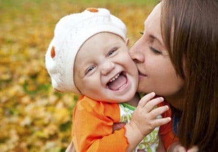 mother kissing child in the fall during mother and child residential addiction treatment program stay
