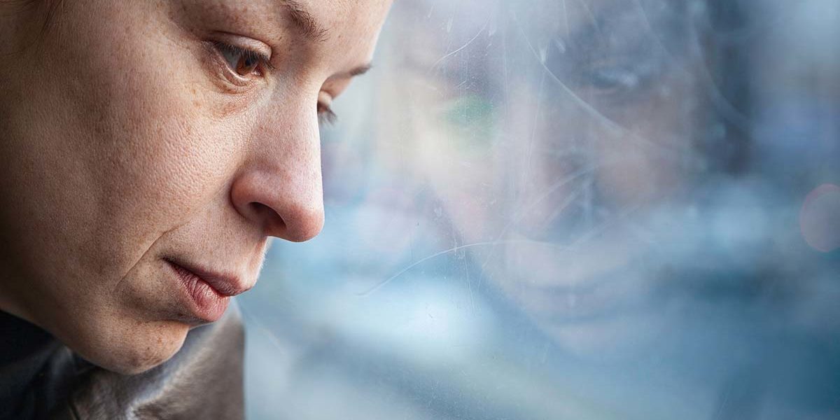 woman looking out the window wondering do I have depression