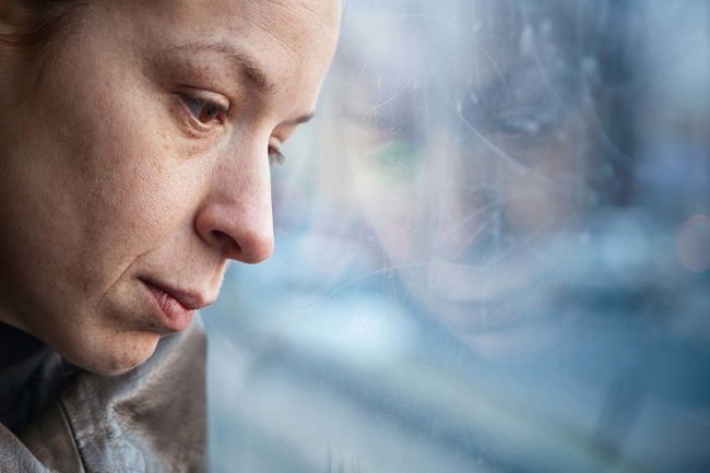 woman looking out the window wondering do I have depression