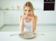 woman with clear plate pondering common eating disorders