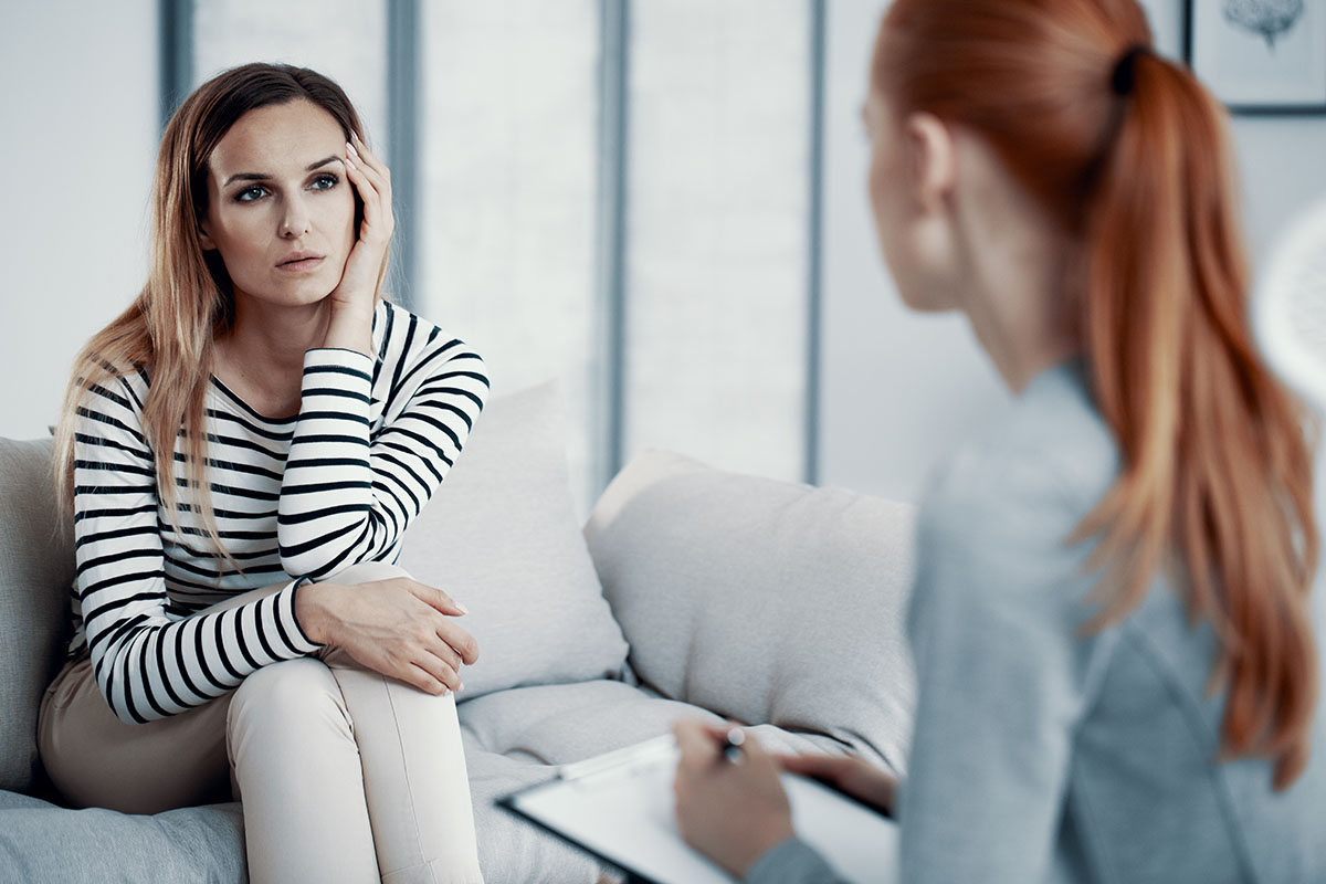 a woman talks to a therapist and wonders do i need eating disorder treatment
