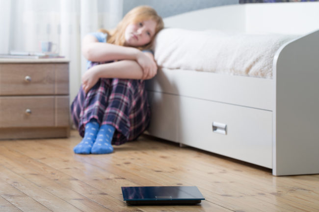 body image and social media a young girl sits on the floor of her bedroom as she considers body image and social media