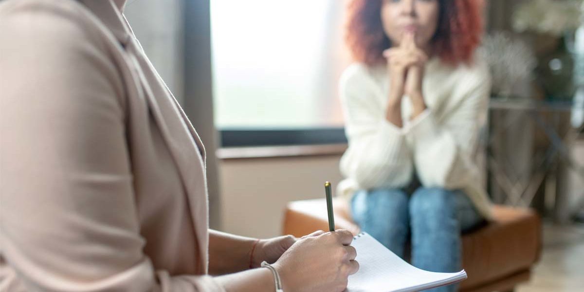 a woman talks to her therapist about attending a treatment program for addiction
