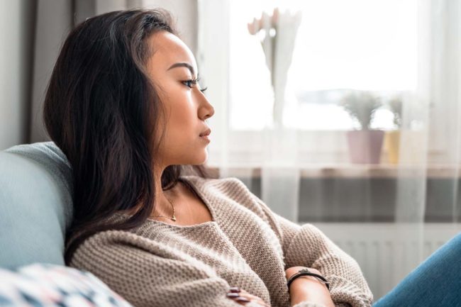 a woman crosses her arms as she thinks about eating disorders in women