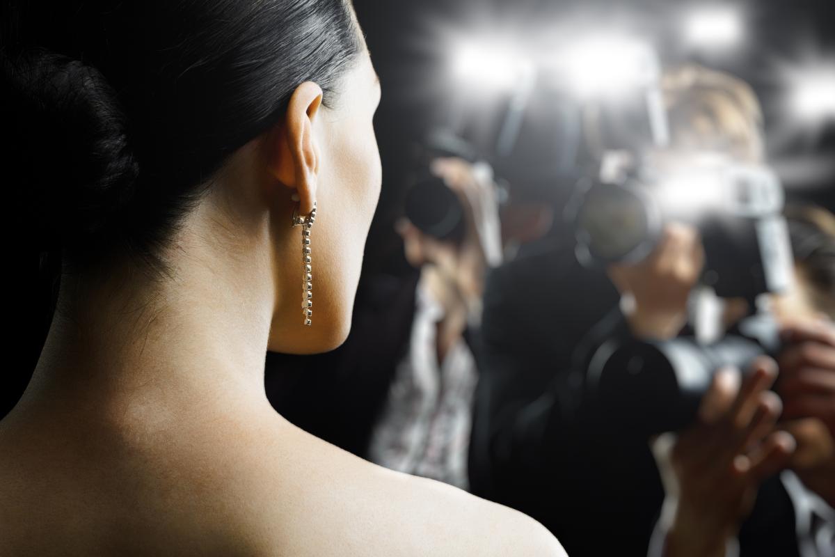 an actress in flashing camera lights considers a celebrity with drug addiction and celebrity rehab