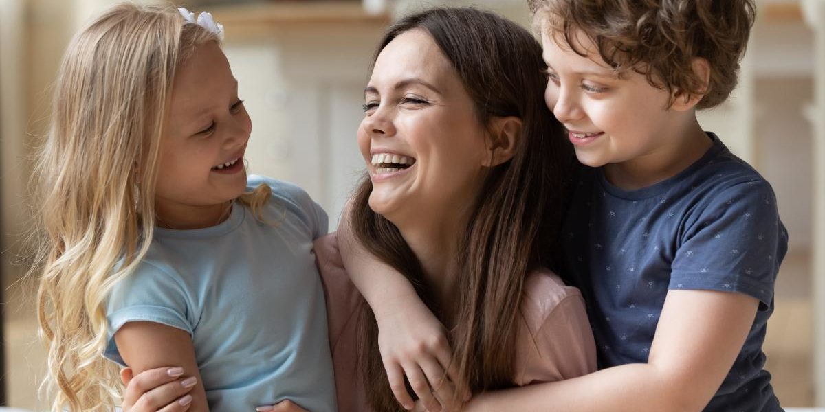 a woman plays with her children after attending a rehab for women with children