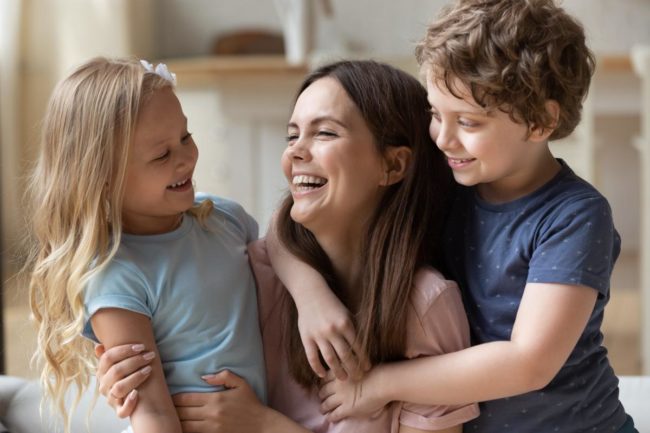 a woman plays with her children after attending a rehab for women with children