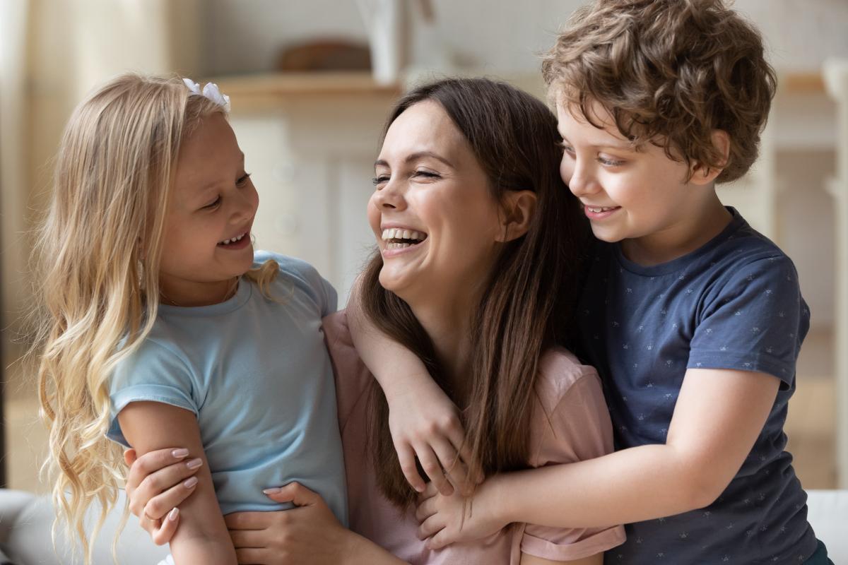 a woman plays with her children after attending a rehab for women with children