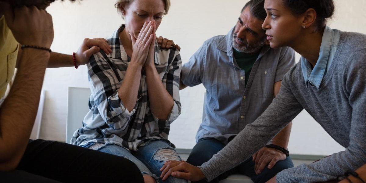 Alcohol Addiction Quotes to Help You in Times of Need a group of people comfort a young woman with alcohol addiction quotes