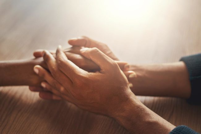 two people holding hands learning how to help someone with anxiety
