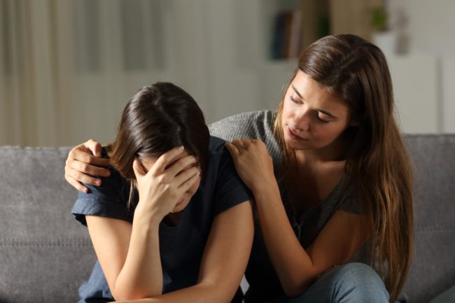 a woman consoling her woman friend and demonstrating how to help someone with bipolar disorder