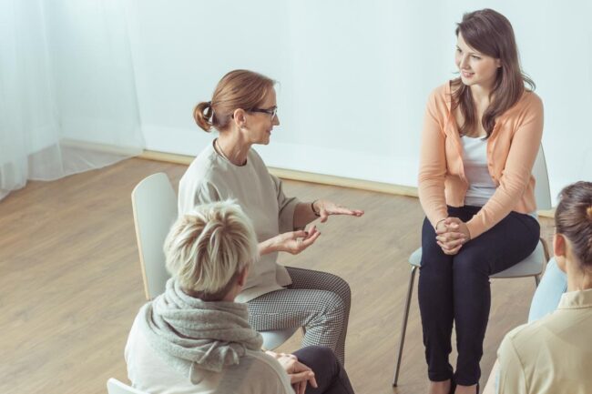 a woman talking about group therapy benefits in group therapy session